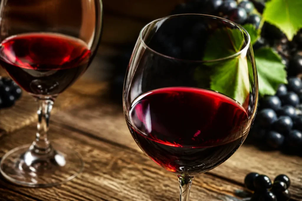 Calici vino rosso intenso con uva nera matura