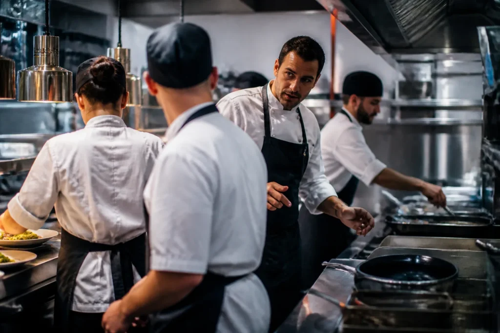 Chef dirige brigata in cucina durante servizio
