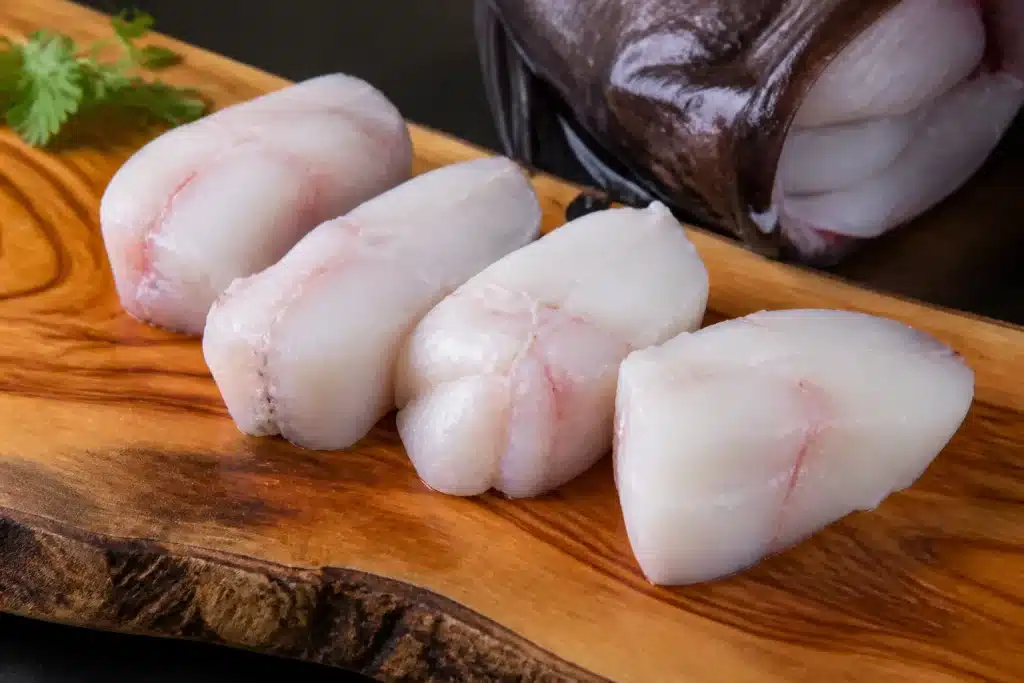Filetti di rana pescatrice tagliati a tranci su tagliere