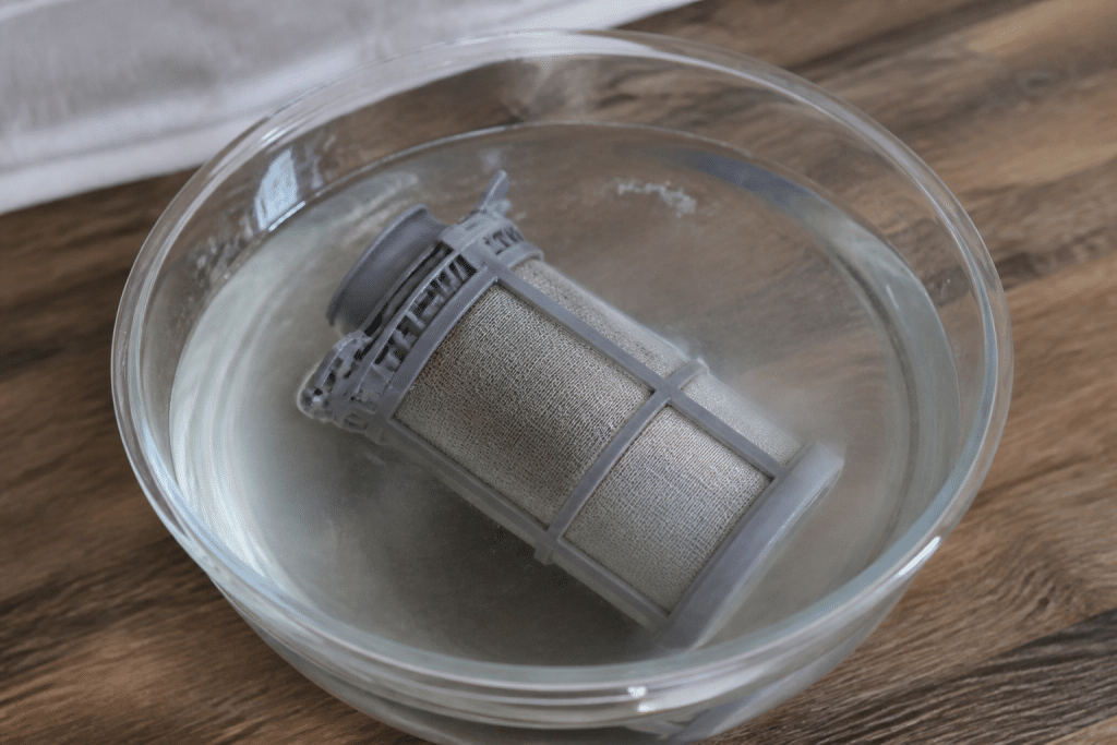 Filtro lavastoviglie immerso in acqua con aceto bianco