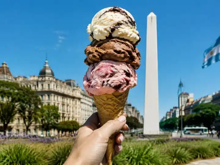 Gigantesco cono gelato italiano sorretto verticalmente da una mano in Argentina.