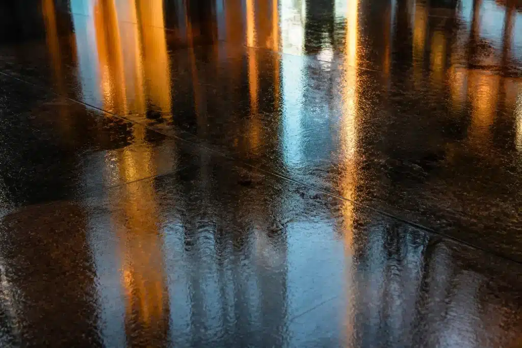 Pavimento lucido bagnato con striature riflettenti di luce