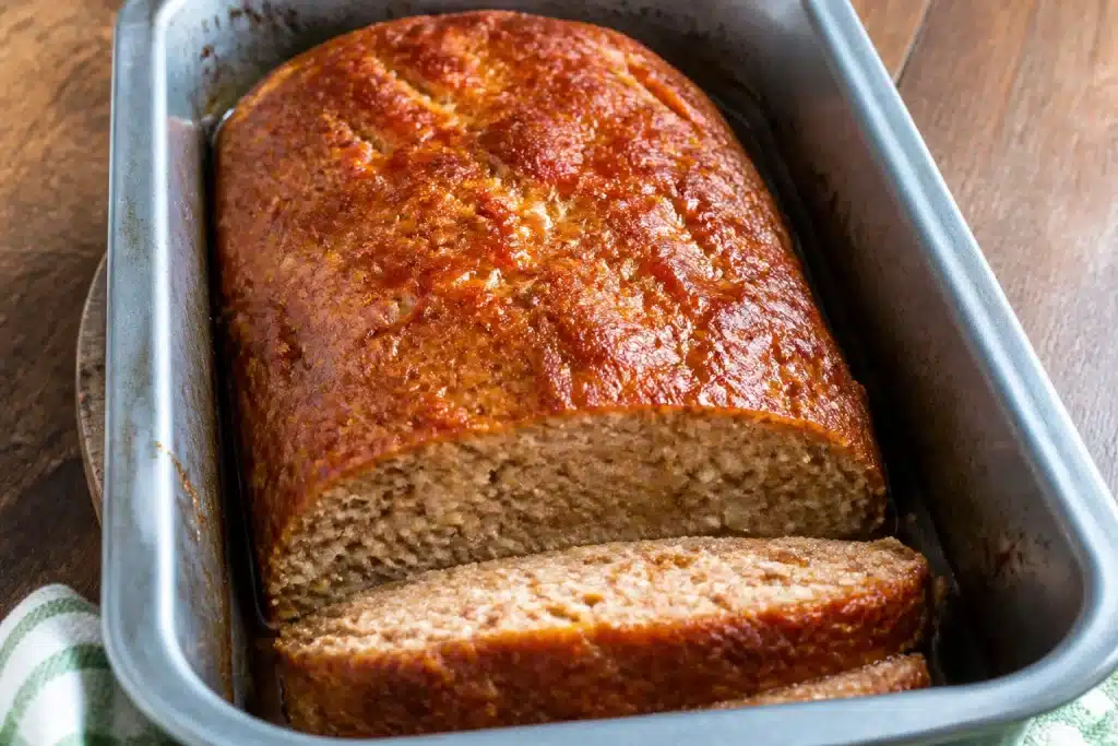Polpettone umido in teglia con pane inzuppato visibile