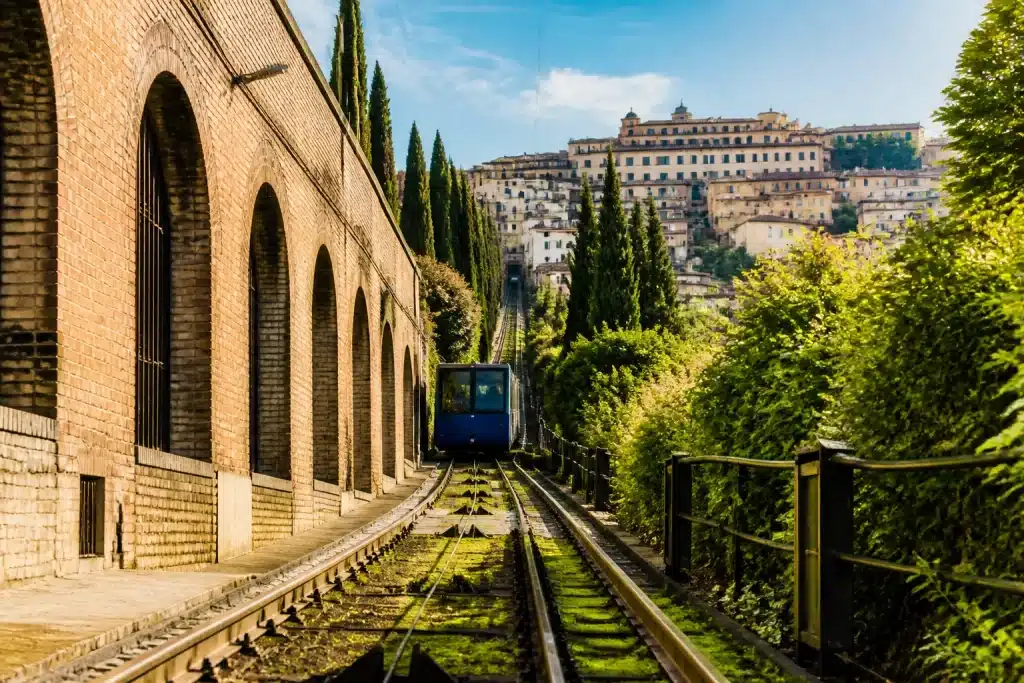 Stazione ferroviaria con binari e funicolare salendo verso centro storico