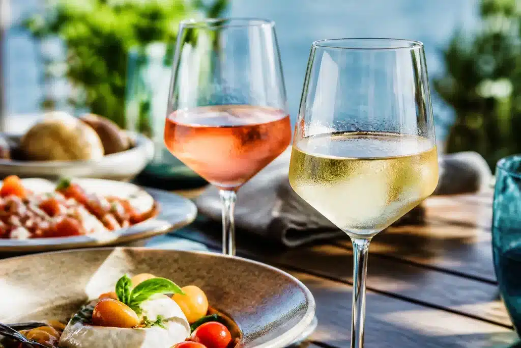Bicchieri di vino bianco e rosato ghiacciati in tavolo estivo