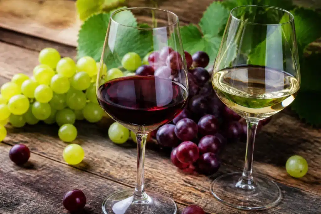 Bicchieri di vino rosso e bianco su tavolo rustico