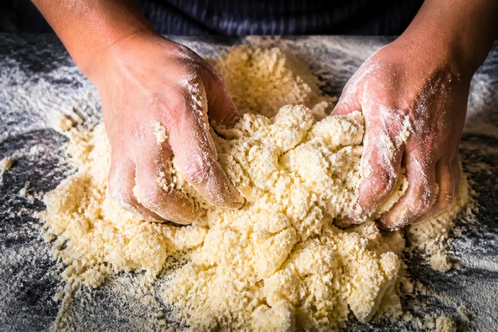 Mani che sabiano burro in impasto granuloso